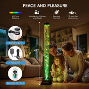 Family interacting with a large bubble tube in a living room setting.