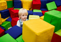 A young child sits in a sensory play area