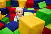 A young child sits in a sensory play area